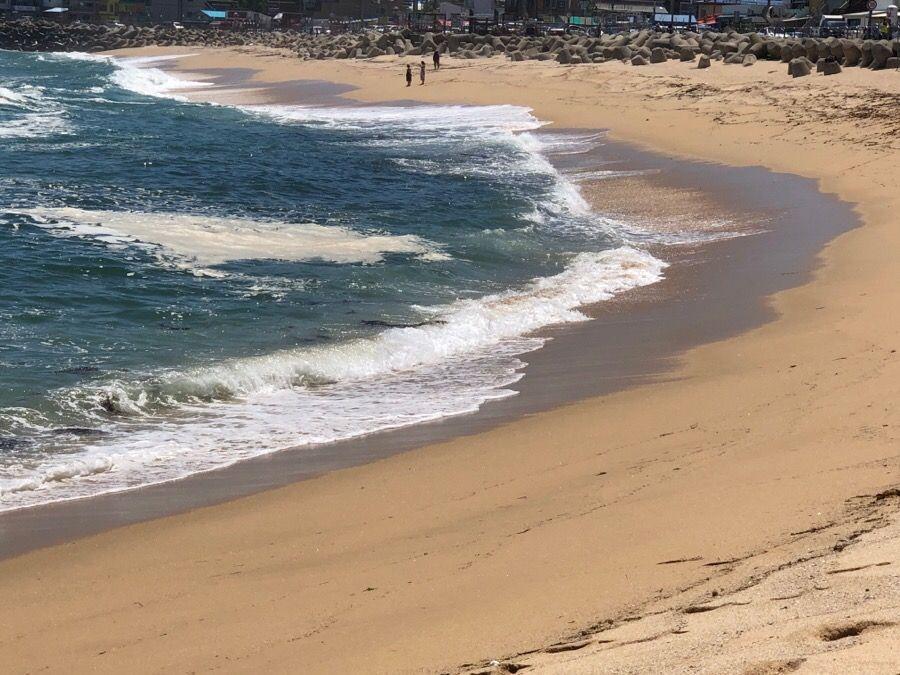 韓國束草燈塔海灘，金色沙灘與藍色海水的景色。